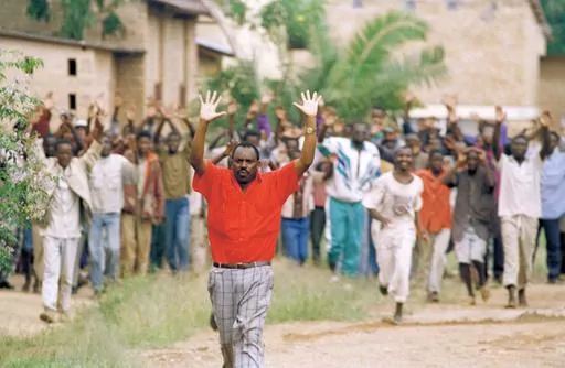 Rwandan refugees hold their hands up and ask for help from Belgian soldiers, who had come to a psychiatric hospital compound outside of Kigali on April 13, 1994. People are patients of this hospital. (AP Photo/Karsten Thielker, File)