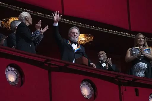 2023 Kennedy Center Honoree, comedian Billy Crystal, center, waves as he is applauded by fellow honorees Dionne Warwick and Queen Latifah, at the 46th Kennedy Center Honors at the John F. Kennedy Center for the Performing Arts in Washington, Sunday, Dec. 3, 2023. (AP Photo/Manuel Balce Ceneta)