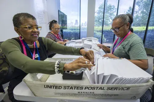 From left, Carol Hamilton, Cristo Carter and Cynthia Huntley prepare ballots to be mailed at the Mecklenburg County Board of Elections in Charlotte, N.C., Sept. 5, 2024. (AP Photo/Nell Redmond, File)