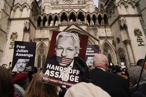Demonstrators hold placards after Stella Assange, wife of Wikileaks founder Julian Assange, released a statement outside the Royal Courts of Justice, in London, Tuesday, March 26, 2024. Two High Court judges said they would grant Assange a new appeal unless U.S. authorities give further assurances about what will happen to him. The case has been adjourned until May 20. (AP Photo/Alberto Pezzali)