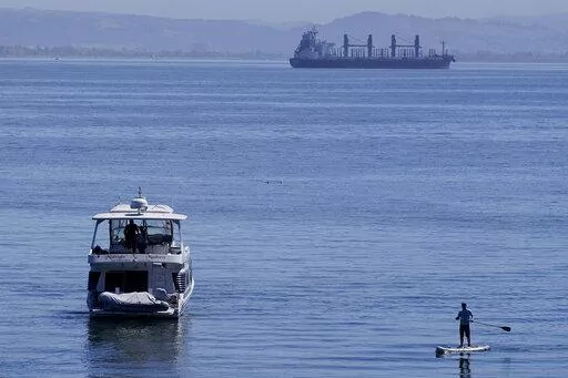 A person paddle boards near a boat in McCovey Cove in San Francisco, Sunday, Sept. 4, 2022. (AP Photo/Jeff Chiu)