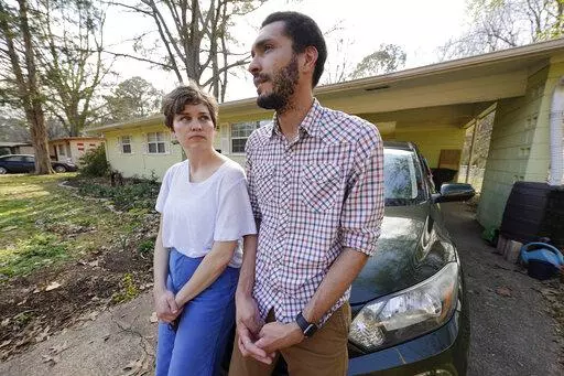 Lauren Rhoades, 32, left, listens as her husband LaQuenza Morgan, 33, speaks on Feb. 24, 2022 about being checked at a roadblock a short distance from their home in north Jackson, Miss. The two are among several plaintiffs in a lawsuit claiming the Jackson police department is violating people's constitutional rights by using roadblocks to check for driver's licenses and car insurance in majority-Black and low-income neighborhoods. The lawsuit was settled on Wednesday, Oct. 5, 2022, and the city