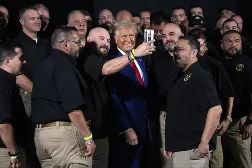 Republican presidential nominee former President Donald Trump talks with members of the U.S. Border Patrol before speaking at a campaign rally, Sunday, Oct. 13, 2024, in Prescott Valley, Ariz. (AP Photo/Evan Vucci)