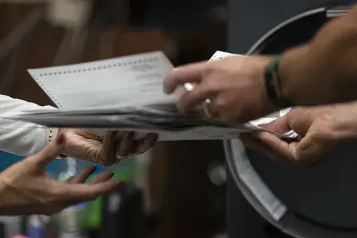 Poll workers sort out early and absentee ballots at the Kenosha Municipal Building on Election Day, Tuesday, Nov. 3, 2020, in Kenosha, Wis. The Wisconsin Supreme Court ruled Friday, July 5, 2024 that officials can place ballot drop boxes around their communities in this fall's elections, overturning its own ruling two years ago limiting their use in the presidential swing state. (AP Photo/Wong Maye-E, File)