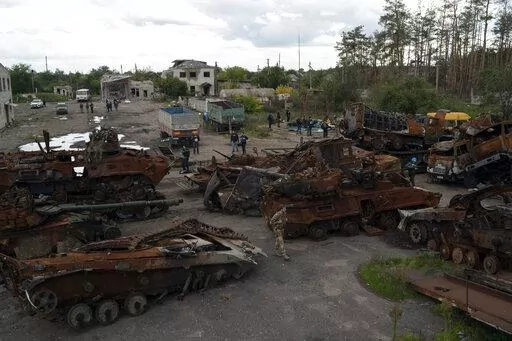 A Ukrainian serviceman and journalists walk between destroyed Russian equipment placed in an area at the recaptured town of Lyman, Ukraine, Wednesday, Oct. 5, 2022. (AP Photo/Leo Correa)