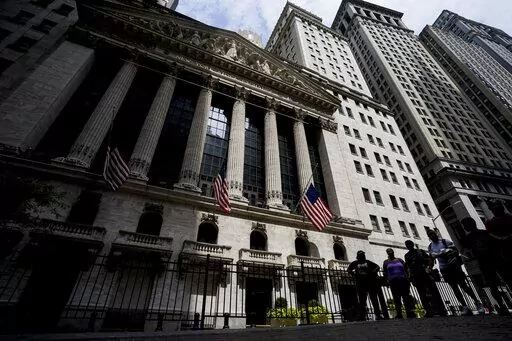 Pedestrians walk past the New York Stock Exchange, Friday, July 8, 2022, in New York. Stocks are swinging between small gains and losses as Wall Street works out what to make of surprisingly strong data on the U.S. jobs market released Friday. 
(AP Photo/John Minchillo)