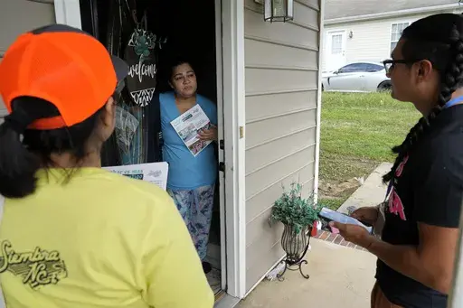 Salvador Fonseca, right, and Elena Jimenez speak with Johanna Ortiz during a voter engagement event for the Latino community in Greensboro, N.C., Saturday, Sept. 21, 2024. (AP Photo/Chuck Burton)