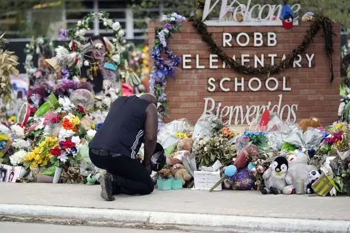 Reggie Daniels pays his respects a memorial at Robb Elementary School, Thursday, June 9, 2022, in Uvalde, Texas. The 19 fourth-graders and two teachers killed at the elementary school are being remembered, Friday, May 24, 2024 as the second anniversary of the one of the deadliest school shootings in U.S. history is marked. (AP Photo/Eric Gay)