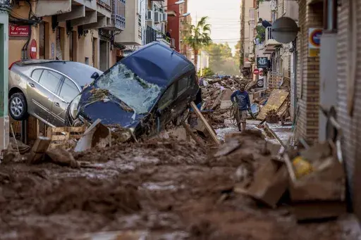 A man walks through a street affected by floods in Valencia, Spain, Nov. 2, 2024. (AP Photo/Manu Fernandez, File)