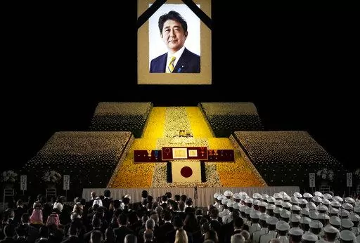A portrait of former Japanese Prime Minister Shinzo Abe hangs on the stage during his state funeral, Tuesday, Sept. 27, 2022, Tokyo. Abe was assassinated in July. (Franck Robichon/Pool Photo via AP)