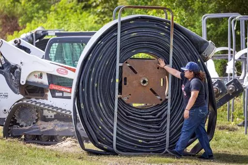 Crews lay out miles of flexible pipeline to help supply fresh water to Jefferson Parish as salt water slowly moves up the Mississippi River on Wednesday, Oct. 4, 2023, in Marrero, La. A mass inflow of salt water from the Gulf of Mexico creeping up the drought-stricken Mississippi River is threatening drinking water supplies in Louisiana. (Chris Granger,/The Times-Picayune/The New Orleans Advocate via AP)