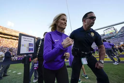 LSU national champion women's basketball head coach Kim Mulkey runs on the sideline before an NCAA college football game against Auburn in Baton Rouge, La., Saturday, Oct. 14, 2023. (AP Photo/Gerald Herbert)