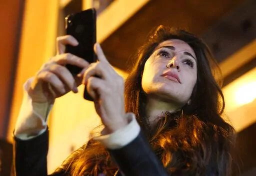 Lebanese Journalist Dima Sadek uses her cellphone to make a video of an anti-government protest, in Beirut, Lebanon, Dec. 4, 2019. The stabbing of author Salman Rushdie on Friday, Aug. 12, 20222 in western New York, has laid bare the divisions within Lebanon’s Shiite community of which some have expressed support for the act while others harshly criticized it leading to death threats against Sadek, a prominent journalist. The assailant, 24-year-old Hadi Matar, is a dual Lebanese-U.S. citizen, 