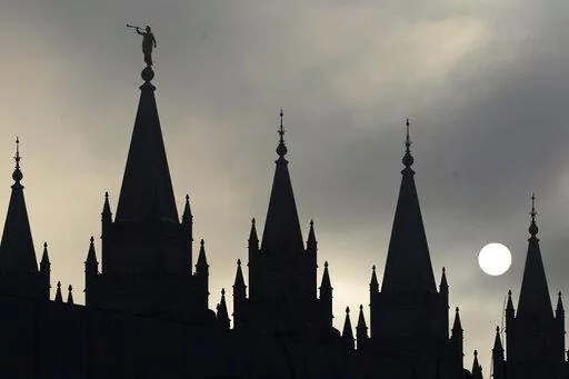 The angel Moroni statue atop the Salt Lake Temple is silhouetted against a cloud-covered sky, at Temple Square in Salt Lake City on Feb. 6, 2013. The U.S. Securities and Exchange Commission says, Tuesday, Feb. 21, 2023, The Church of Jesus Christ of Latter-day Saints and its investment arm will pay $5 million in fines. The SEC alleges the church used shell companies to obscure the size of the portfolio under the church's control.(AP Photo/Rick Bowmer, File)