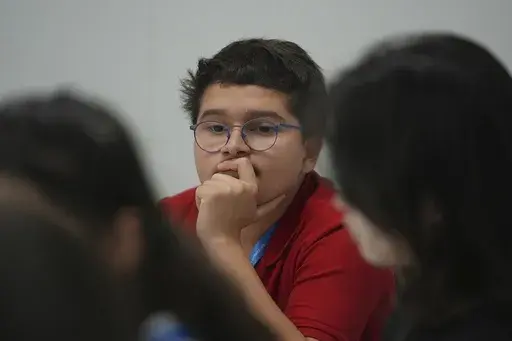 Francisco Vera Manzanares, 15, center, a climate activist from Colombia, listens during a forum with young activists, Tuesday, Nov. 12, 2024, at the COP29 U.N. Climate Summit in Baku, Azerbaijan. (AP Photo/Joshua A. Bickel)