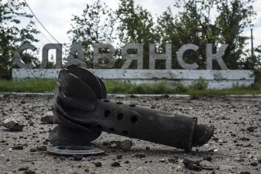 A part of the mortar shell is seen in front of a sign that reads 'Slovyansk', after heavy fighting between pro-Russian fighters and Ukrainian government troops just outside Slovyansk, eastern Ukraine, Wednesday, July 9, 2014. The eastern Ukrainian city of Slovyansk was occupied by pro-Russian separatists for months in 2014. Now its people are preparing to defend their community again as the fighting draws closer and invites a major battle. Slovyansk is a city of splintered loyalties, with some r