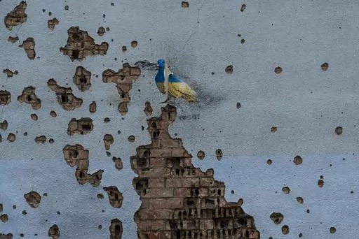 A dove painted by artist TvBoy adorns the wall of a building damaged by Russian shelling attacks in Irpin, Ukraine, Friday, July 7, 2023. Life in the capital of a war-torn country seems normal on the surface. In the mornings, people rush to their work holding cups of coffee. Streets are filled with cars, and in the evenings restaurants are packed. But the details tell another story. (AP Photo/Jae C. Hong, File)