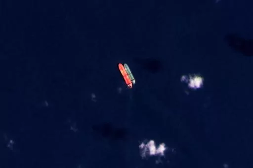 In this satellite photo provided by Planet Labs PBC, vessels identified as the Virgo, left, and the Suez Rajan, by the advocacy group United Against Nuclear Iran, are seen in the South China Sea on Feb. 13, 2022. A Greek shipper has pleaded guilty to a charge over it smuggling sanctioned Iranian crude oil and agreed to pay a $2.4 million fine, U.S. federal court papers seen Thursday, Sept. 7, 2023 by The Associated Press show. (Planet Labs PBC via AP, File)