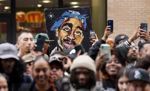 An image of the late rapper and actor Tupac Shakur appears among fans during a ceremony honoring Shakur with a star on the Hollywood Walk of Fame on Wednesday, June 7, 2023, in Los Angeles. The unsolved killing of Shakur has taken a major turn. Duane “Keffe D” Davis was arrested Friday morning, although the exact charge or charges were not immediately clear, according to two officials with first-hand knowledge of the arrest. The renewed activity comes nearly 30 years after Shakur was gunned 