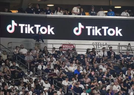 Fans sit under a TikTok ad at a baseball game at Yankee Stadium, April 14, 2023, in New York. A bill that could lead to the popular video-sharing app TikTok being unavailable in the United States is quickly gaining traction in the House. Lawmakers advanced legislation against TikTok Thursday as they voiced concerns about the potential for the platform to surveil and manipulate Americans. (AP Photo/Frank Franklin II, File)