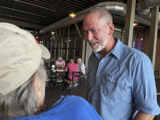 Independent Dan Osborn, a challenger to two-term Republican Sen. Deb Fischer, chats with patrons of a brewery in Beatrice, Neb., July 30, 2024. (AP Photo/Margery Beck)