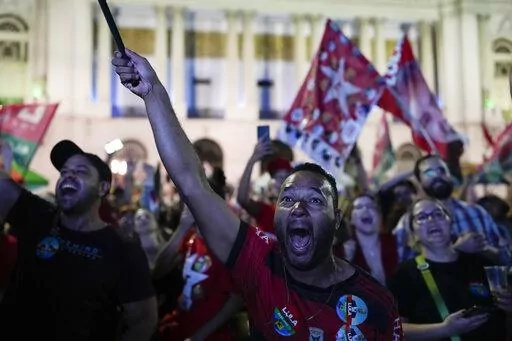 Followers of former Brazilian President Luiz Inacio Lula da Silva, who is running for president again, react to partial results after general election polls closed in Rio de Janeiro, Brazil, Sunday, Oct. 2, 2022. (AP Photo/Silvia Izquierdo)