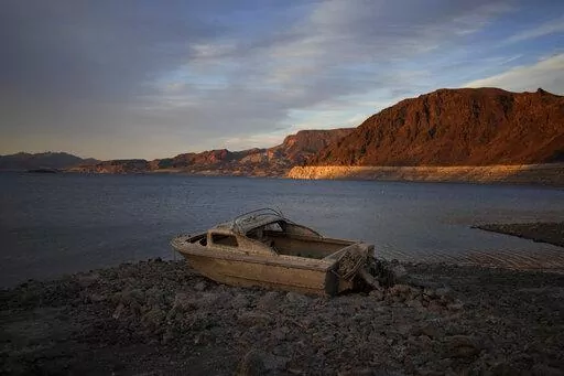 A formerly sunken boat sits high and dry along the shoreline of Lake Mead at the Lake Mead National Recreation Area, on May 10, 2022, near Boulder City, Nev. Another body has surfaced at Lake Mead, this time in a swimming area where water levels have dropped as the Colorado River reservoir behind Hoover Dam recedes due to drought and climate change. The National Park Service did not say in a statement how long officials think the corpse was submerged in the Boulder Beach area before it was found