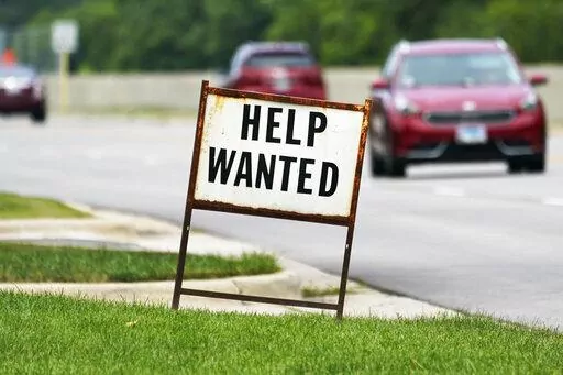 A help wanted sign is displayed at a gas station in Mount Prospect, Ill., Tuesday, July 27, 2021.  Fewer Americans applied for unemployment benefits last week as layoffs remain at historically low levels.  Jobless claims fell by 5,000 to 166,000 for the week ending April 2, 2022 the Labor Department reported Thursday.  (AP Photo/Nam Y. Huh)