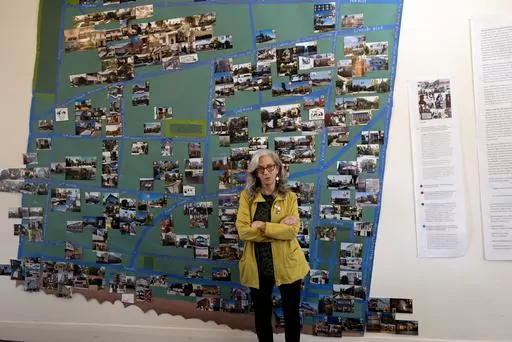 Writer and activist Judy Branfman stands by a map she created as part of a gallery installation at Beyond Baroque gallery, Friday, Nov. 3, 2023, in the Venice Beach area of Los Angeles. The gallery installation offers a unique art-meets-data look at the eviction crisis in the Venice Beach neighborhood. The exhibit titled "Where Has All The (affordable) Housing Gone?" gathers maps, photos, statistics, paintings, poems and the stories of people who have been evicted from their homes, including the