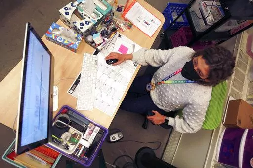 Art teacher Sarah Hager works at a computer in her classroom at Cleveland Middle School on Sunday, Jan. 23, 2022, in Albuquerque, N.M. Public school systems – which often have limited budgets and cybersecurity expertise -- have become an inviting target for ransomware gangs. The coronavirus pandemic has forced schools to turn increasingly toward virtual learning, making them more dependent on technology and more vulnerable to cyber-extortion. (AP Photo/Cedar Attanasio)