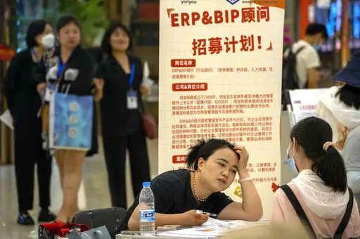 A recruiter talks with an applicant at a booth at a job fair at a shopping center in Beijing, on June 9, 2023. A record of more than one in five young Chinese are out of work, their career ambitions at least temporarily derailed by a depressed job market as the economy struggles to regain momentum after its long bout with COVID-19. (AP Photo/Mark Schiefelbein, File)