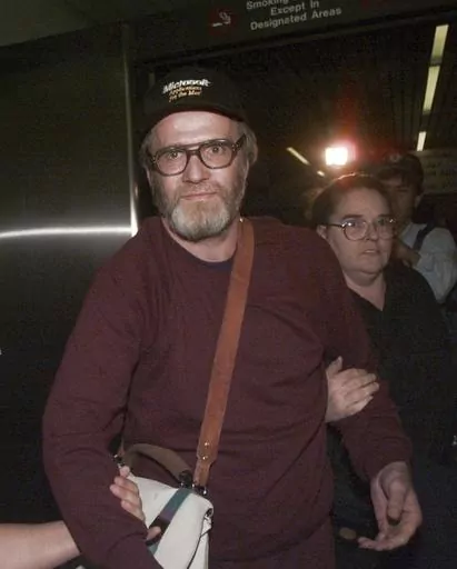 FILE — James Lewis is escorted through Boston's Logan Airport, Friday Oct. 13, 1995, after being released from the Federal Correctional Institution in Oklahoma. Lewis, the suspect in the 1982 Tylenol murders, was found dead Sunday, July 9, 2023 at his home in Cambridge, Mass., law-enforcement sources said. (AP Photo/Charles Krupa, File)