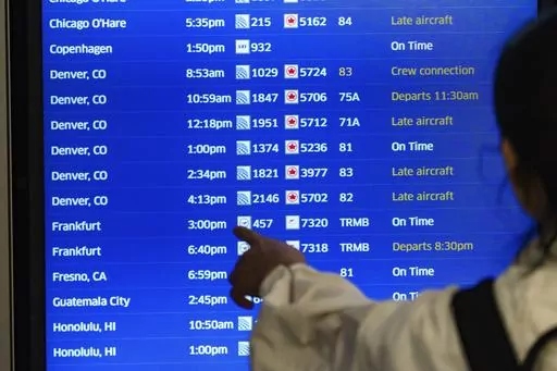 A traveler checks the departures flight board at the United Airlines terminal at Los Angeles International airport, on Wednesday, June 28, 2023, in Los Angeles. (AP Photo/Damian Dovarganes)
