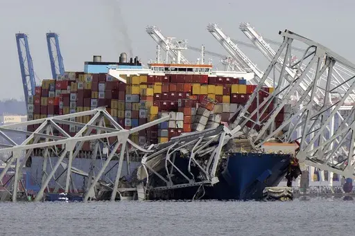 The cargo ship Dali is stuck under part of the structure of the Francis Scott Key Bridge after the ship hit the bridge, Tuesday, March 26, 2024, as seen from Pasadena, Md. (AP Photo/Mark Schiefelbein, File)