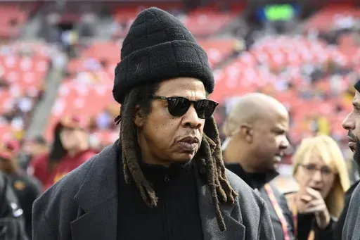 Musician Jay-Z stands on the field before an NFL football game between the Washington Commanders and Dallas Cowboys, on Nov. 24, 2024, in Landover, Md. (AP Photo/Nick Wass, File)