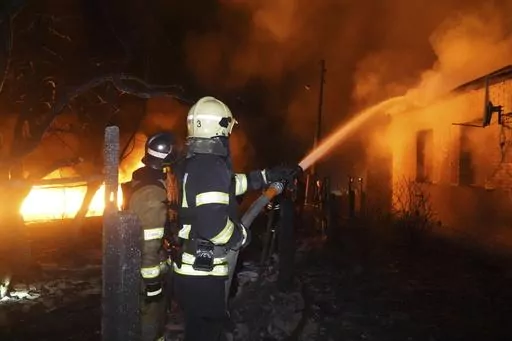 Firefighters extinguish a fire after a Russian attack on residential neighborhood in Kharkiv, Ukraine Saturday, Feb. 10, 2024. According to the city administration, about a dozen private houses were under fire and scores of people were evacuated after Russian drones strike on a residential area. (AP Photo/Andrii Marienko)