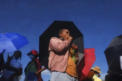 Vekile Sesha waits in line outside a garment factory in Maseru, Lesotho Monday, Feb. 28, 2022. Sesha lost her job when the coronavirus pandemic hit the world two years ago and the global fashion industry crumple. when, faced with collapsing demand, brands canceled orders worth billions of dollars and few felt the effects so harshly as the tens of millions of workers, most of them women, who stitched the world's clothes. (AP Photo/Neo Ntsoma)
