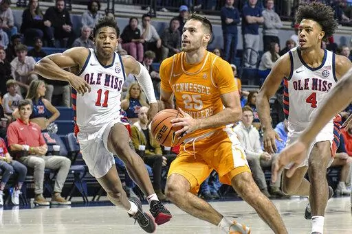 Tennessee guard Santiago Vescovi (25) drives the lane as Mississippi guard Matthew Murrell (11) and Mississippi forward Jaemyn Brakefield (4) defend in the first half in an NCAA college basketball game, Wednesday, Dec. 28, 2022 in Oxford, Miss. (AP Photo/Bruce Newman)