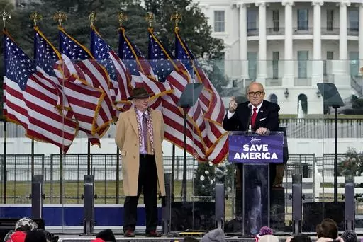 Chapman University law professor John Eastman stands at left as former New York Mayor Rudolph Giuliani speaks in Washington at a rally in support of President Donald Trump, called the "Save America Rally" on Jan. 6, 2021. The latest federal indictment against Donald Trump vividly illustrates the extent to which the former president's final weeks in office were consumed by a struggle over the law, with two determined groups of attorneys fighting it out as the future of American democracy hung in 