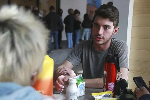 High school senior Cruz Davis-Martinez speaks with fellow students at the New Mexico School for the Arts on Thursday, March 10, 2022, in Santa Fe, N.M. Davis Martinez stands to benefit from a $85 million program to make college free for state residents if he attends the University of New Mexico. The program was funded mostly with one-time federal aid, leaving supporters concerned about how long the state can sustain it. (AP Photo/Cedar Attanasio)
