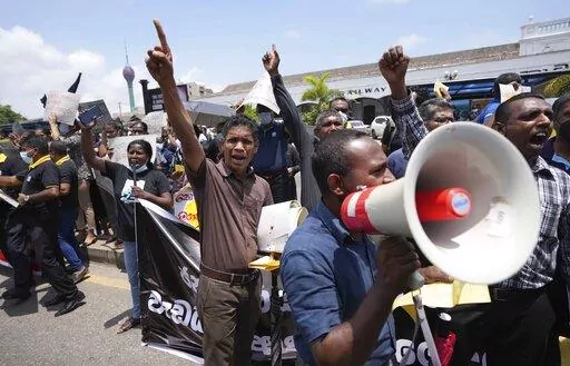 Sri Lankans representing various government establishments shout slogans against the government during a protest in Colombo, Sri Lanka, Wednesday, April 20, 2022. Thousands of people across Sri Lanka are taking to the streets, a day after police opened fire at demonstrators, killing one person and injuring 13 others, reigniting widespread protests amid the country's worst economic crisis in decades. Placards reads demands against privatisation and increasing  costs of living. (AP Photo/Eranga Ja