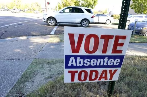 A sign encouraging people to vote absentee stands outside the Hinds County Courthouse in Jackson, Miss., Tuesday, Oct. 6, 2020. The 2023 general election absentee ballots in a different part of Mississippi, Jones County, will be several days late because a candidate dropped out of a race on Thursday, Sept. 21, 2023, and the ballot there had to be redone after a substitute candidate was named, according to Circuit Clerk Concetta Brooks. (AP Photo/Rogelio V. Solis, File)
