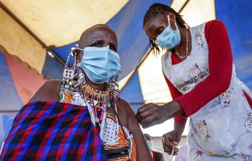A Maasai woman receives the AstraZeneca coronavirus vaccine at a clinic in Kimana, southern Kenya on Aug. 28, 2021. The World Health Organization said Thursday, April 14, 2022 that the number of coronavirus cases and deaths in Africa have dropped to their lowest levels since the pandemic began, marking the longest decline yet seen in the disease. (AP Photo/Brian Inganga, File)