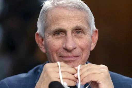 Dr. Anthony Fauci, Director of the National Institute of Allergy and Infectious Diseases, holds his face mask in his hands as he attends a House Committee on Appropriations subcommittee hearing on about the budget request for the National Institutes of Health, May 11, 2022, on Capitol Hill in Washington.  Fauci, the government’s top infectious disease expert, says he plans to retire by the end of President Joe Biden’s term in January 2025. Fauci, 81, became director of the National Institute