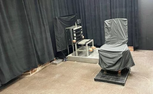 This photo provided by the South Carolina Dept. of Corrections shows the state’s death chamber in Columbia, S.C., including the electric chair, right,  and a firing squad chair, left. The agency renovated its capital punishment facility to include a metal chair with restraints facing a wall with a rectangular opening several feet away after South Carolina lawmakers added the firing squad to the state’s execution methods in 2021. ( South Carolina Dept. of Corrections via AP)