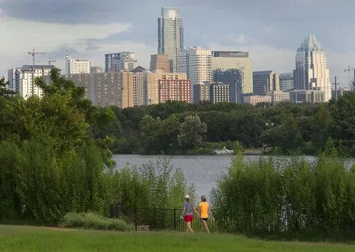 Women walk through the Lakeshore area of Austin, Texas, with the skyline in the background on Aug. 31, 2016. The Texas capital became the largest U.S. city to challenge its 2020 census figures by filing an appeal with the Census Bureau in May 2022, saying that it has more than the 961,855 residents counted during the nation's once-a-decade head count. (Ralph Barrera/Austin American-Statesman via AP, File)
