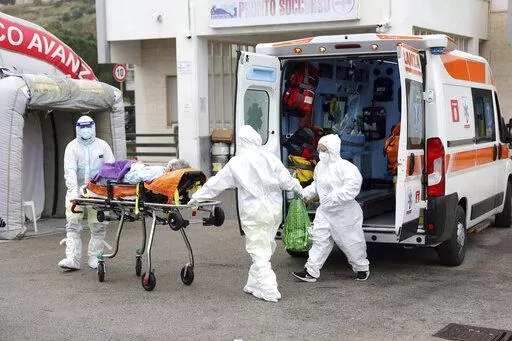 An ambulance for covid emergency unload a patient at the Cervello hospital in Palermo, Sicily, where tented field hospitals have been set up in front of three hospitals to relieve the pressure on the emergency room and allow ambulances to get their patients into a bed rather than wait in line in the parking lot, Friday, Jan. 7, 2022. Sicily has seen its caseload double in recent days, from around 6,000 a day to 14,000 on Thursday, and has just under 1,000 people hospitalized with the virus. (Alb