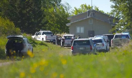 In this image taken from video, Canadian law enforcement personnel surrounded a residence on the James Smith Cree First Nation reservation in Saskatchewan, Canada, Tuesday, Sept. 6, 2022, as they search for a suspect in a series of stabbings. (AP Photo/Robert Bumsted)
