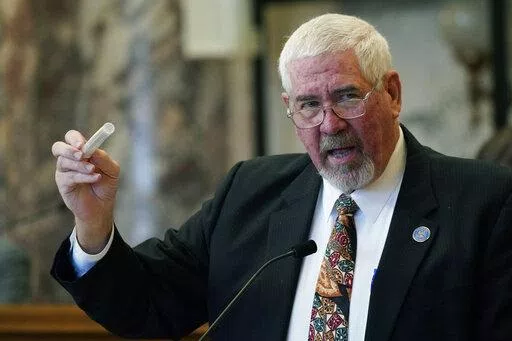 Sen. Kevin Blackwell, R-Southaven, lead negotiator, holds a tube containing a cigarette and a rolled hemp cigarette to illustrate to lawmakers what specific portions of the Mississippi Medical Cannabis Equivalency Units would look like during his presentation of the Mississippi Medical Cannabis Act in the Senate Chamber at the Mississippi State Capitol in Jackson, Miss., Thursday, Jan. 13, 2022. The body passed the act. (AP Photo/Rogelio V. Solis)