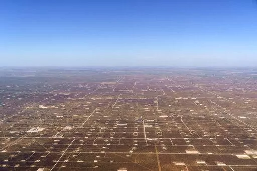 Patches of land housing oil pumpjacks dot the landscape of the Permian Basin in Midland, Texas, Monday, Oct. 11, 2021. Carbon Mapper, a partnership of university researchers and NASA’s Jet Propulsion Laboratory, documented massive amounts of methane venting into the atmosphere from oil and gas operations across the Permian, a 250-mile-wide bone-dry expanse along the Texas-New Mexico border that a billion years ago was the bottom of a shallow sea. (AP Photo/David Goldman)